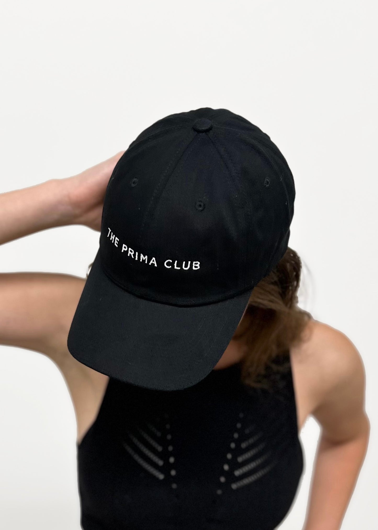 model looking down wearing black The Prima Club hat
