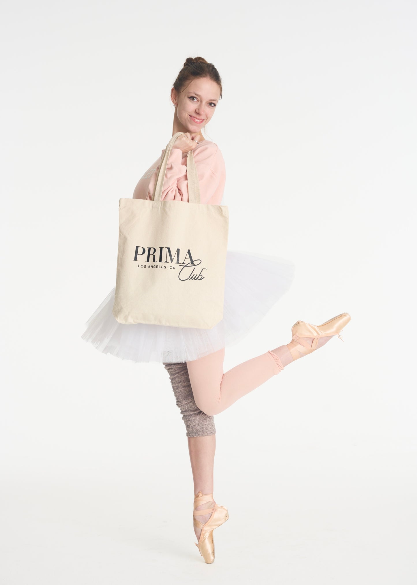 model holding canvas tote bag with Black Prima Club Logo
