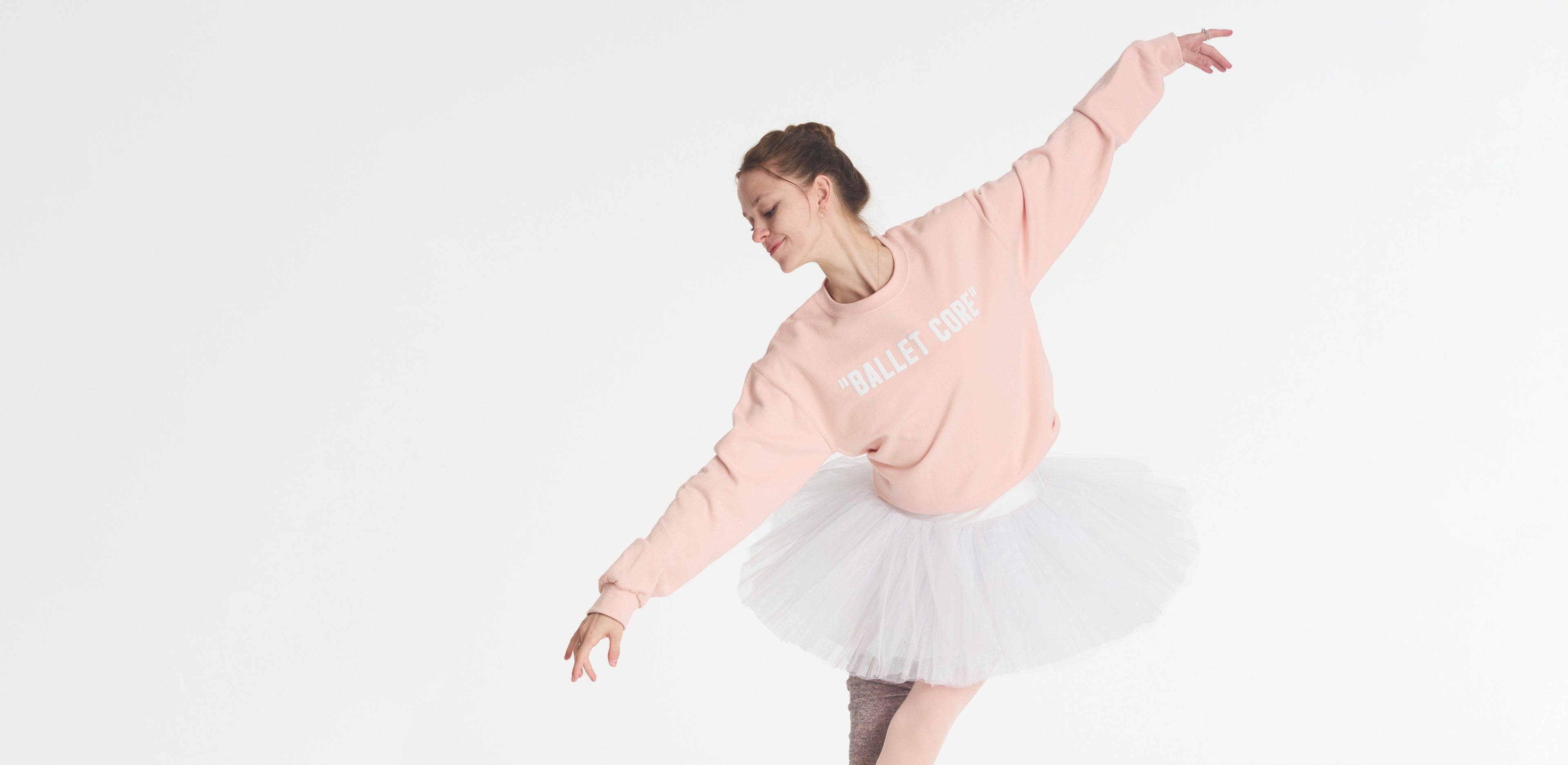 dancer wearing blush pink ballet core crewneck, posing in ballet position.