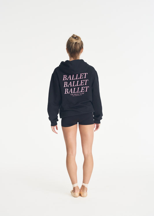 model wearing black hoodie with pink ballet design