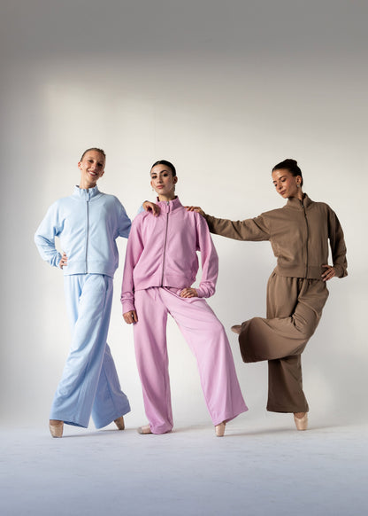 Three models wearing matching lounge sets in light blue, pink, and brown, posed together against a neutral studio background.